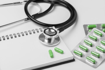 stethoscope equipment and psychotherapy pills modern capsule green healthy on notebook