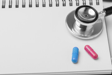 stethoscope equipment and psychotherapy pills modern capsule pink and blue healthy on notebook