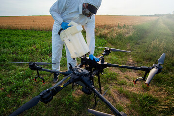 Modern technologies in agriculture. Industrial drone at green field for spraying pesticides to...