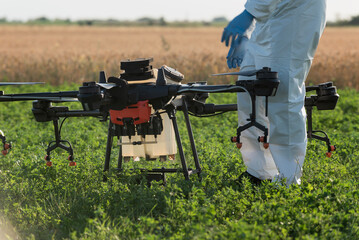 Modern technologies in agriculture. Industrial drone at green field for spraying pesticides to...