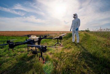 Modern technologies in agriculture. Industrial drone at green field for spraying pesticides to...