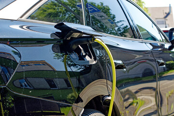 Electric car is charging, close-up of plugged-in cable