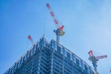 高層ビル建設のクレーンと青空 © kanzilyou