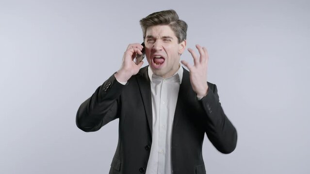 Angry mature businessman quarreling, screaming talking on mobile phone. Mischief boss manager man in stress, conflict 