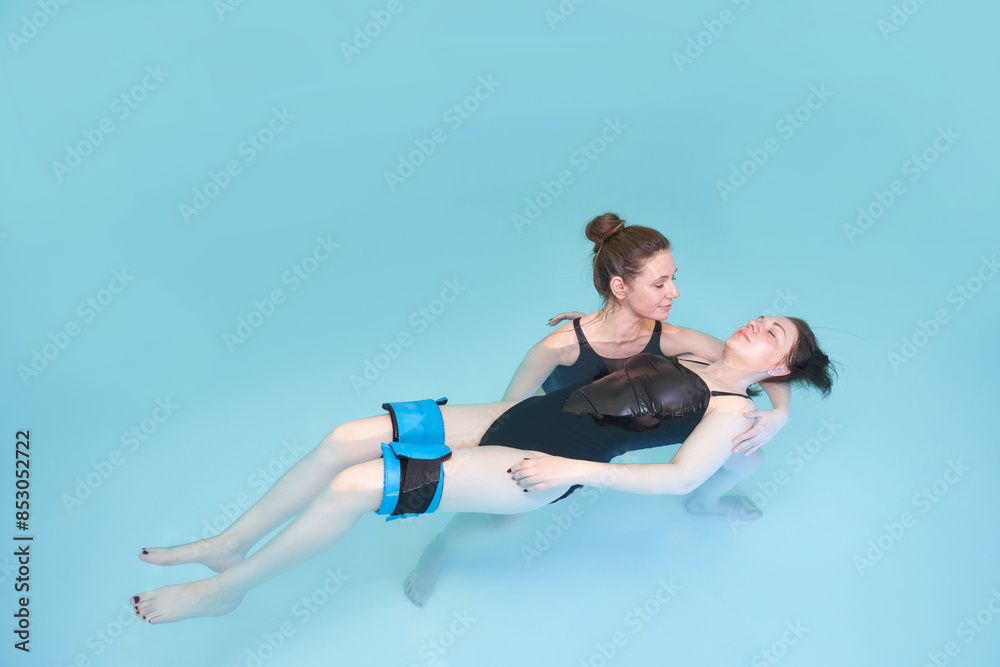 Wall mural two woman in pool. watsu. blue water rehabilitation massage. aqua therapy exercise. physio medical f