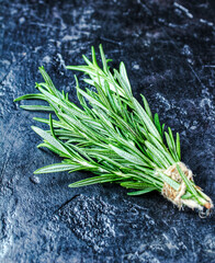Rosemary on a black background. A bunch of fresh green fragrant rosemary. Spices and herbs that are used for cooking meat and fish. Culinary concept.