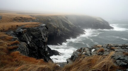 Obraz premium Rocky Beach with Waves Crashing: A dramatic shot of waves crashing against large rocks on a rugged coastline, with mist and spray creating a dynamic and powerful scene.