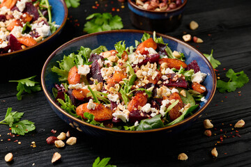 Warm baked carrots and beetroot salad with feta cheese and roasted hazelnuts