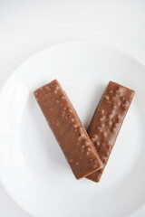 A sweet chocolate bar on a white plate.Waffle chocolate bar on a white background.