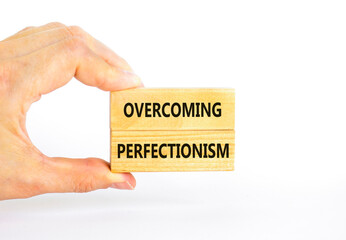 Overcoming perfectionism symbol. Concept words Overcoming perfectionism on beautiful wooden block. Beautiful white background. Businessman hand. Business Overcoming perfectionism concept. Copy space.