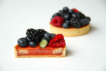 Texture inside of a tart. French dessert. Berry tart decorated with organic fresh blueberries, raspberries and blackberries. Back view. There is a copy space for your text.