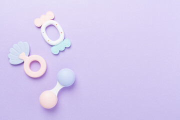 Colorful baby rattles and toys on color background, top view