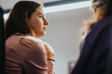 A young woman is seen deep in thought during a business meeting, showcasing concentration and...