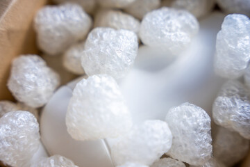 Eco packaging of parcels and white biodegradable filler. Box is filled with a filler safety for environment. Delivery of goods, parcels, delivery service, nature protection and recycling concept