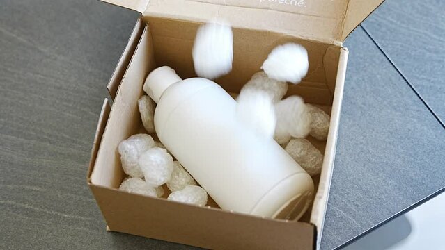 Eco packaging of parcels and white biodegradable filler. Box is filled with a filler safety for environment. Delivery of goods, parcels, delivery service, nature protection and recycling concept