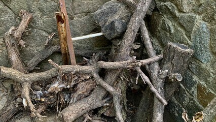 Pile dry wooden branches logs stone wall outdoor fire fireplace forest garden yard home house