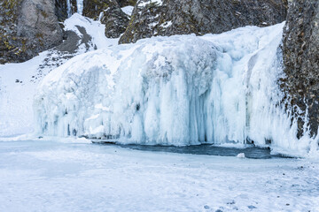 Close-up Winter view of the Stjornarfoss waterfall (Stjórnarfoss) in the south of Iceland. Snowy canyon, frozen river in the canyon. Famous must-see touristic spot. Wonderful Icelandic landscape.