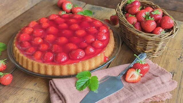 Erdbberkuchen mit einem Korb voll Erdbeeren