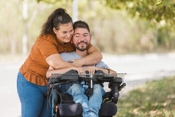 Smiling couple holding hands, a man with a disability and his wife on a pleasant autumn walk. Love, care, and marriage concepts.