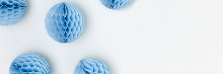 Banner with tissue paper balls scattered on a blue background. Place for text.