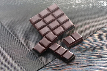 Dark chocolate. Broken chocolate bar on kitchen table