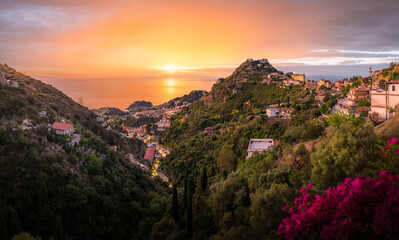 Sunset over Taormina, Sicily, showcasing the picturesque hillside village and Mediterranean scenery.