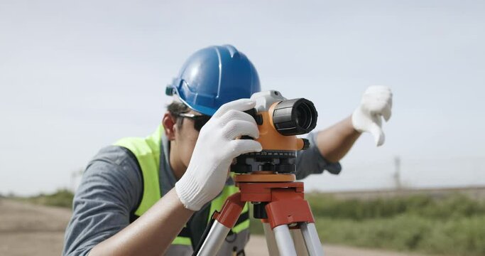 Civil engineer working with theodolite under a road construction bridge.  engineer surveyor is taking measurements with surveying instruments during a new road construction.