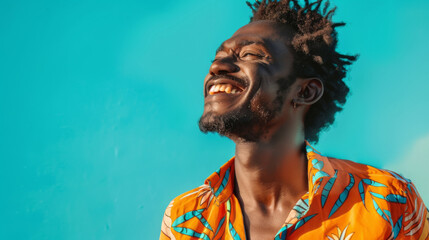 Happy Brazilian man in a bright shirt posing on a blue background. Young African American man having fun indoors. Lifestyle.
