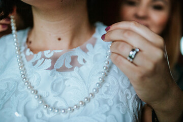 A close-up shot of a bride's neck adorned with a delicate necklace, emphasizing her elegant wedding attire.