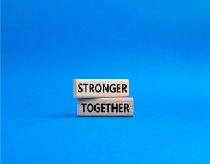 Stronger together symbol. Wooden blocks with words Stronger together. Beautiful blue background. Stronger together concept. Copy space.