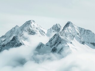 Obraz premium Snow-covered mountain peaks rise through clouds, creating a serene, ethereal landscape. The sky is overcast, casting a soft light over the majestic scene.