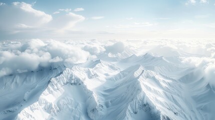 Fototapeta premium Snow-capped mountains stretch beneath a sea of fluffy clouds, illuminated by a soft, pale blue sky. The rugged terrain is accentuated by sharp ridges and deep valleys.