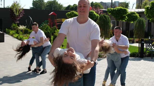 Guy and girl dance beautifully bachata in city center Kharkiv, Ukraine Several couples in jeans and T-shirts dance in nature