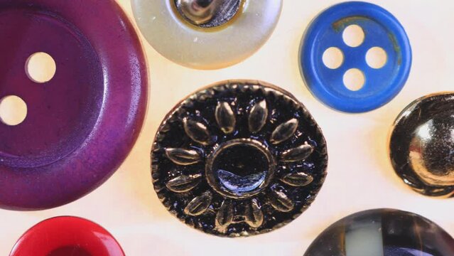 Sewing buttons for clothes. Concept of color, luxurious feel, fashion, dressmaking, sewing, tailor. Close-up extreme macro moving slider shot of a pile of colorful dress buttons
