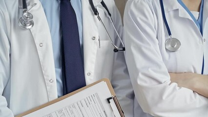 Professional healthcare team in uniform. Two doctors with stethoscopes are standing straight with arms crossed. Medicine concept
