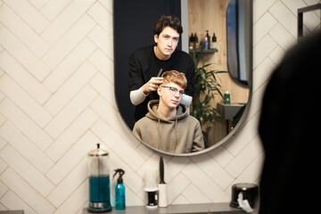 Experienced barber working in contemporary hairdressing salon