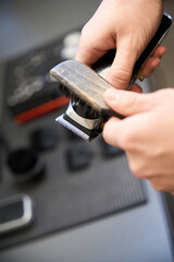 Cropped view of hairdresser cleaning hair clipper