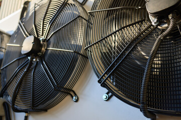 Industrial Cooling Fans mounted on a wall with ventilation equipment and machinery in closeup focus