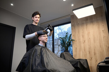 Experienced barber working in contemporary hairdressing salon
