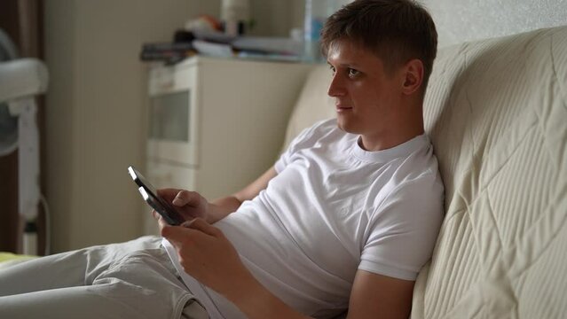 Portrait of crypto trader male clicking with fingers on two smartphones screen to farming Hamster Kombat cryptocurrency coin in online application. Crypto trader male extract crypto coins on phone.