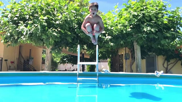 Video en c&aacute;mara lenta de un ni&ntilde;o feliz de 8 a&ntilde;os buceando y jugando en el agua de una piscina en verano, agua azul, sonriente y divertido