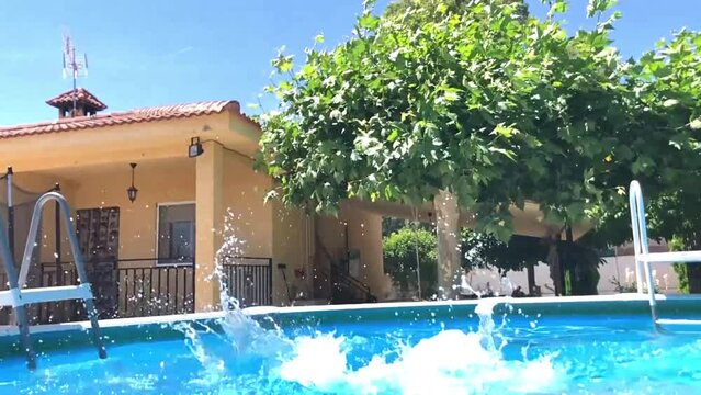 Video en c&aacute;mara lenta de un ni&ntilde;o feliz de 8 a&ntilde;os buceando y jugando en el agua de una piscina en verano, agua azul, sonriente y divertido