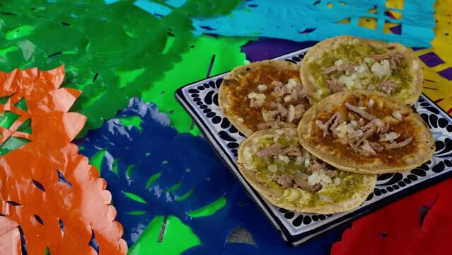 Mexican chalupas on a talavera plate with a mexican background, Pan right