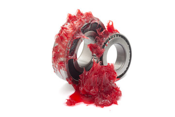 Two tapered roller bearings with red lithium grease (Machinery Lubrication). Isolated on a white...