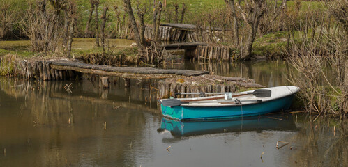 Obraz premium An old boat in a lake with old bridges in creepy forest