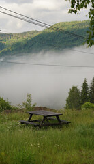 Picnic table in foggy mountains early morning