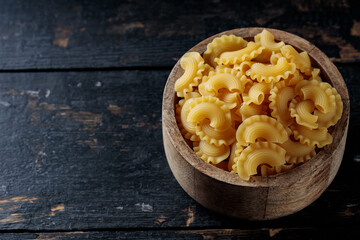 Uncooked Creste di Gallo Pasta in Wooden Bowl, Copy Space