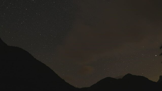 timelapse con vista da un ambiente naturale di montagna in Italia sul cielo notturno pieno di stelle visibili e la rotazione terrestre durante l'estate fino alle prime luci dell'alba