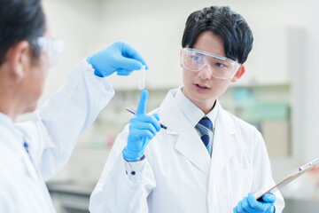 テストチューブに入ったサンプルを確認する研究者