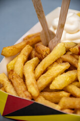 Belgian street and fast food, paper box in colors of Belgian flag with fried potato frit chips and...